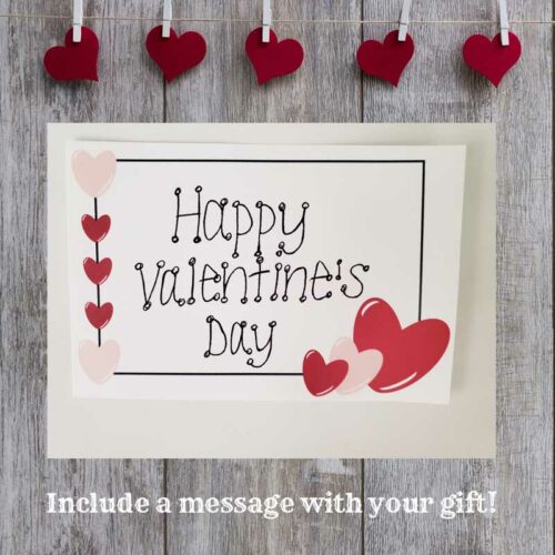 Happy Valentine's Day gift note on wood background with hearts pinned to a string by clothes pins and the words include a message with your gift