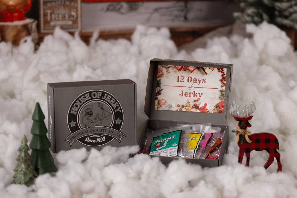 12DaysofJerkyPart2(8) box that has an insert that says 12 days of jerky with some assorted jerky bags inside it with a holiday background